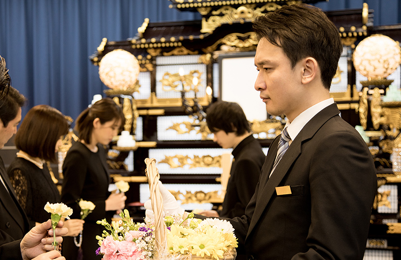 かごを持つ男性葬祭ディレクター