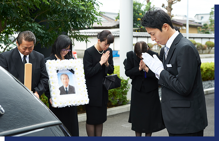 遺族に手を合わせる男性葬祭ディレクター